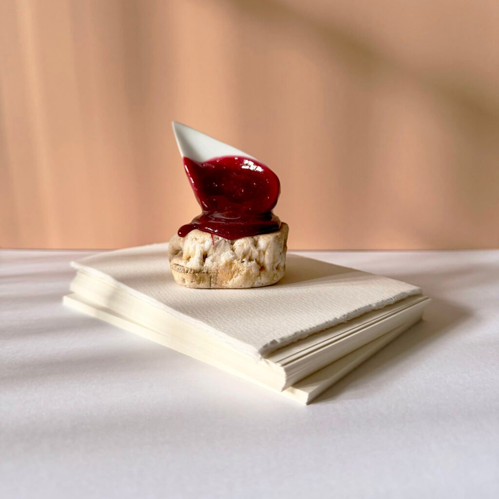 Crumpet and Jam by Alexandru Regent (salvaged marine rock, porcelain spoon, epoxy resin, 2025)
